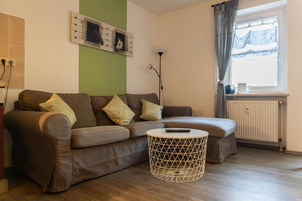 a living room with a brown couch and a table at Ferienwohnung mit zwei Schlafzimmern und Balkon - b56485 in Weißenstadt