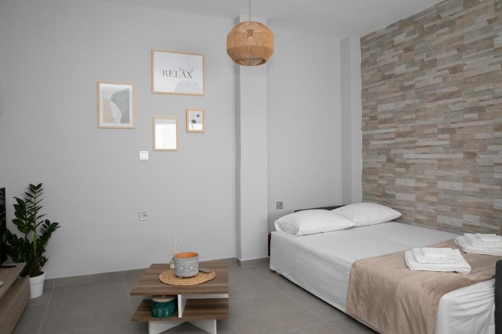 a bedroom with a bed and a brick wall at Suite of Liberty in Kos Town
