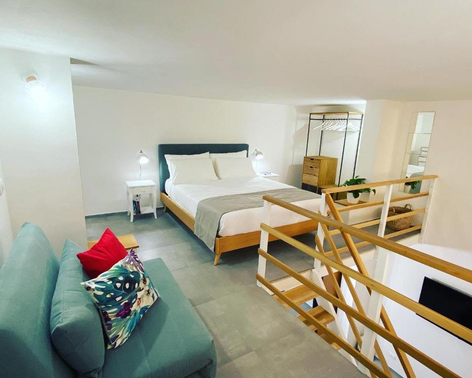 een slaapkamer met een bed en een bank in een kamer bij Casa Artesano, appartamento San Michele in Trapani