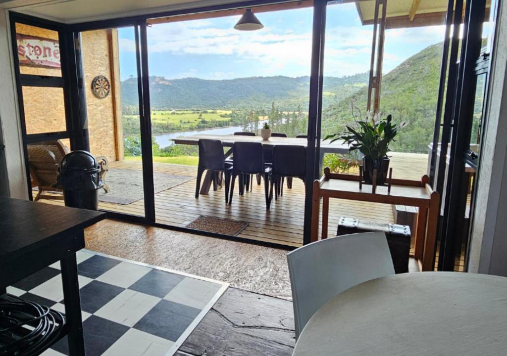 a dining room with a view of a table and chairs at Cloud 9 Estate - Chalet in Knysna
