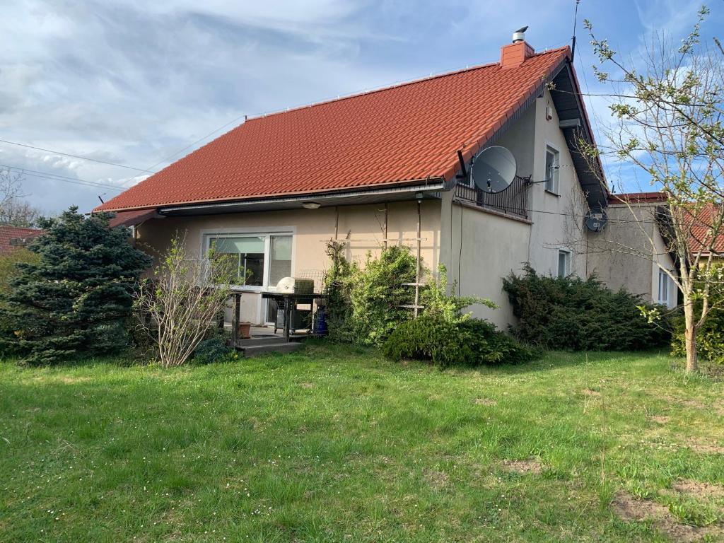 a house with a red roof and a yard at Dom z Ogrodem blisko Trójmiasta i Kaszub in Dobrzewino