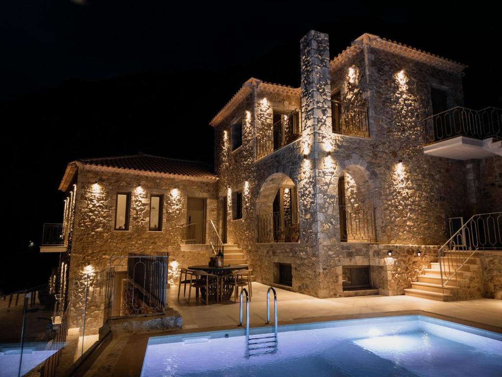 una gran casa de piedra con piscina por la noche en Orithyia prime living, en Kalamata