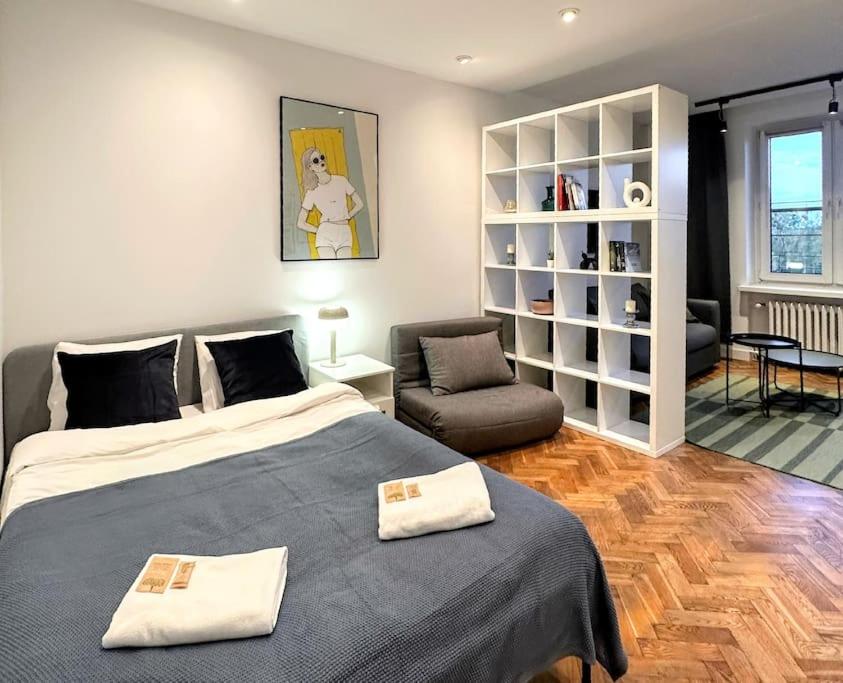 a bedroom with a bed and a couch and a chair at Warsaw Concierge Grójecka View in Warsaw