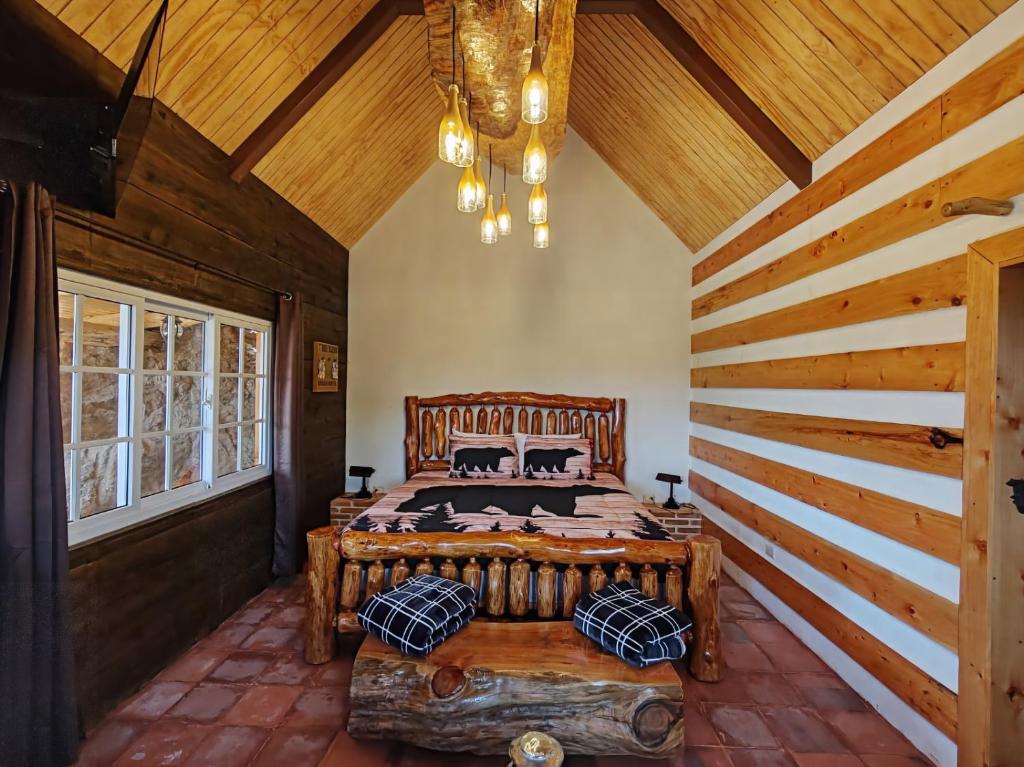 een slaapkamer met een groot bed in een kamer met houten plafonds bij Finca Chuchiyá cabañas Tecpan in Tecpán Guatemala