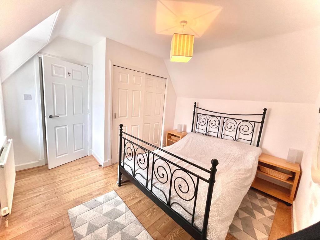a bedroom with a black bed and a wooden floor at The Crows Nest in Eyemouth