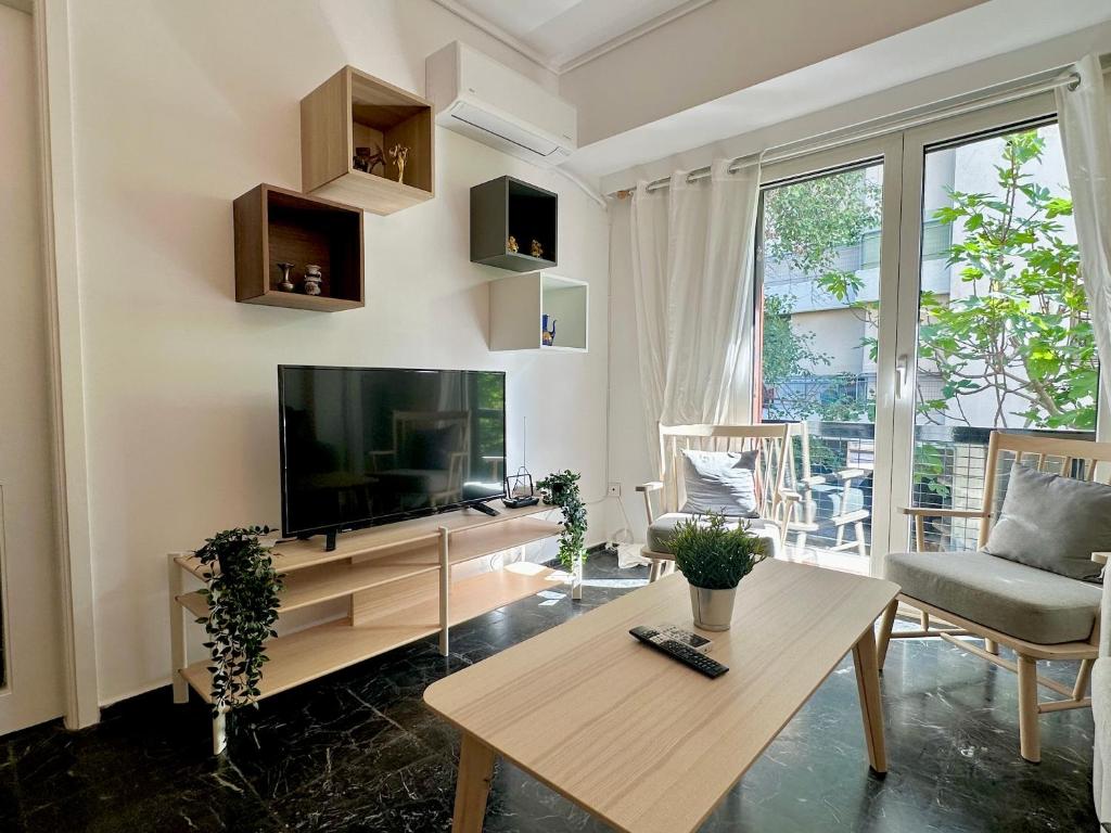 sala de estar con TV y mesa en Apartment in the heart of glyfada en Atenas
