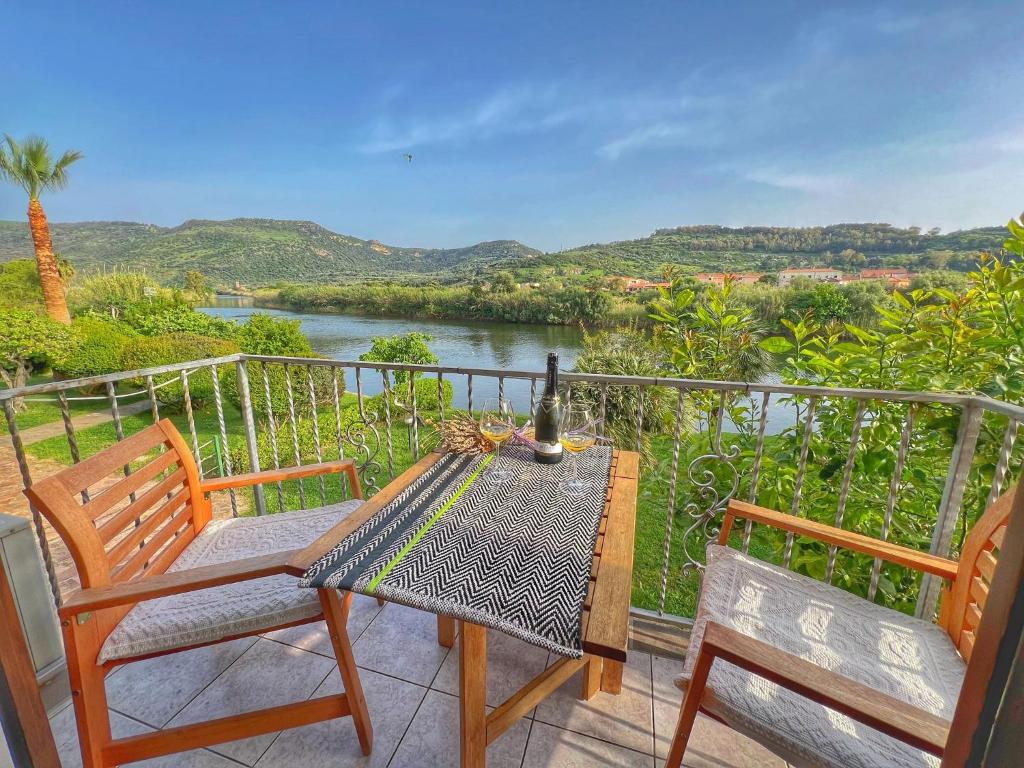 - Balcón con mesa y sillas y vistas al río en Bosa Apartments "House on the River", en Bosa