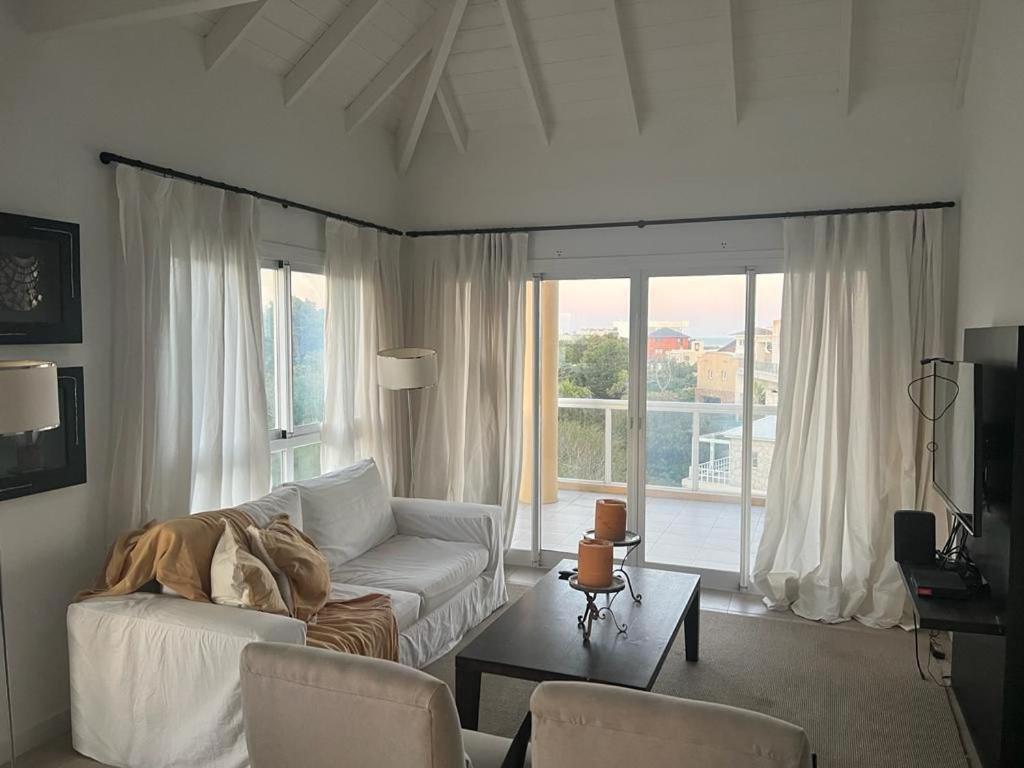 sala de estar con sofá blanco y mesa en Espectacular departamento con vista al mar en Cariló