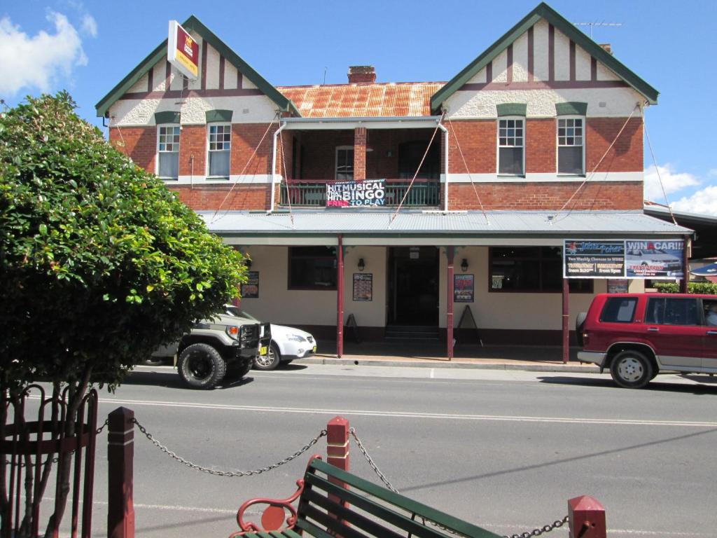 a building on the corner of a street with a bench at Maclean Hotel in Maclean
