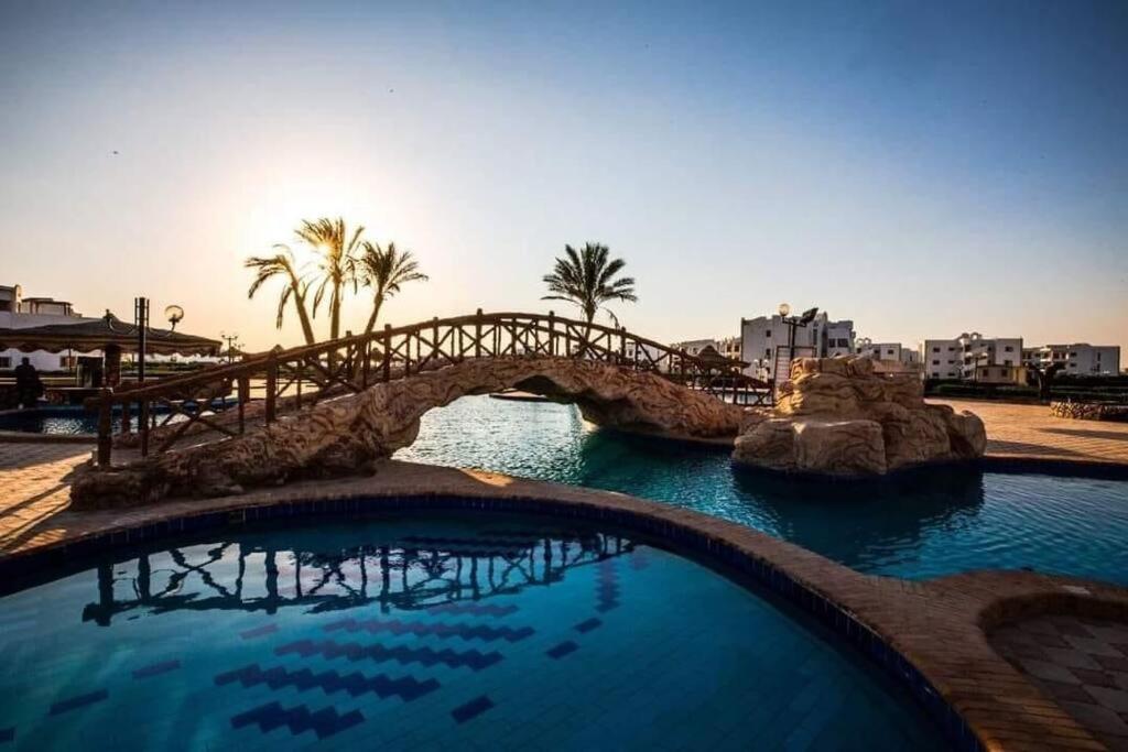 a bridge over a body of water with palm trees at Golden beach 2 Ras sedr Cozy chalet in Ras Sedr