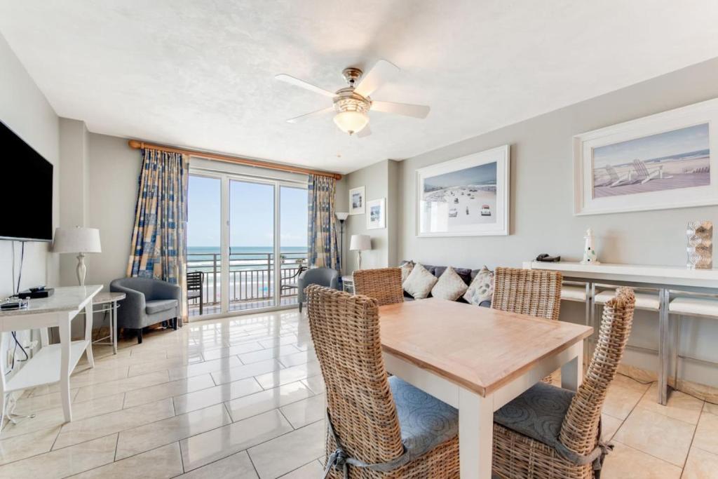 een eetkamer en woonkamer met een tafel en stoelen bij Oceanfront Bliss 3BR Direct Ocean Front Retreat on the 4th Floor at The WyndhamOcean Walk Resort in Daytona Beach