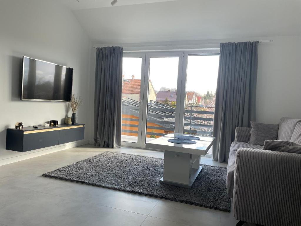 sala de estar con sofá, TV y mesa en Apartament Skłodowskiej, en Łańcut