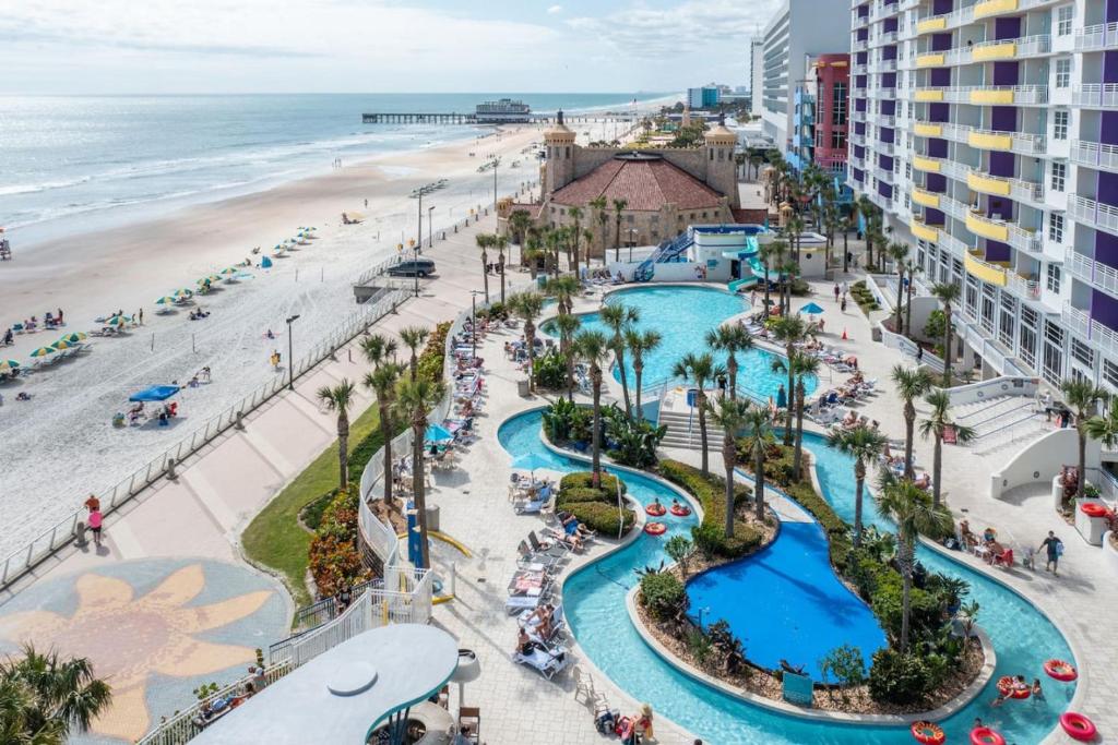 デイトナビーチにあるSeaside Splendor! 1BR Oasis with Private Oceanfront Balcony at Wyndham Oceanwalkのリゾートのビーチとプールの空中の景色を望めます。