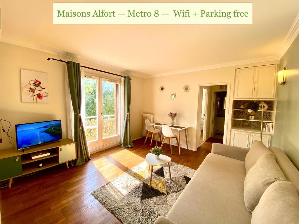 uma sala de estar com um sofá e uma televisão em Maisons Alfort - Cosy appartement em Maisons-Alfort