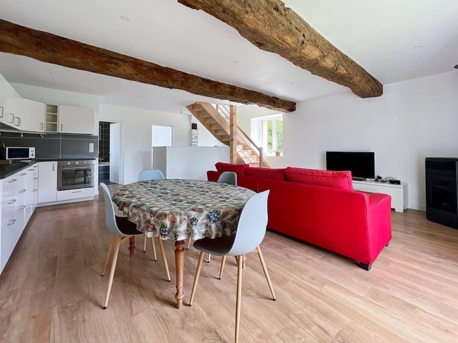 sala de estar con mesa y sofá rojo en La Villa Coudray - Au Calme - Spacieuse, en Chavagne