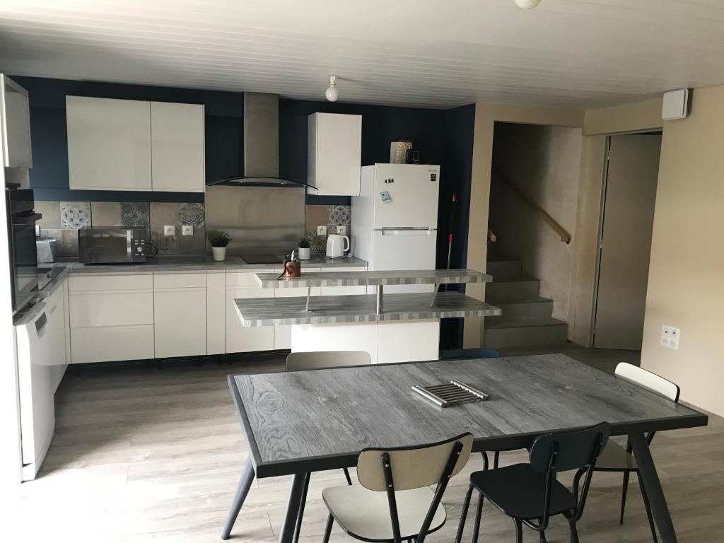 une cuisine avec une table et des chaises dans l'établissement Maison centre du village, à Grand-Village-Plage