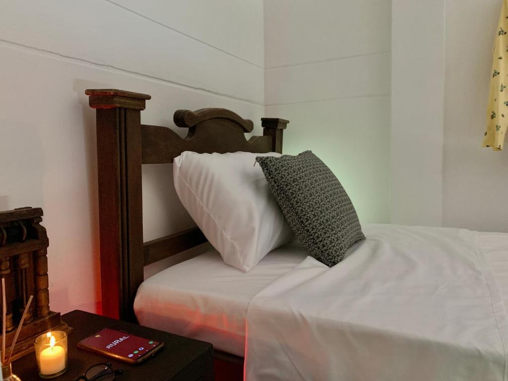 a bed with a pillow and a candle on a table at Habitación Independiente y baño privado - RURAL in Girón