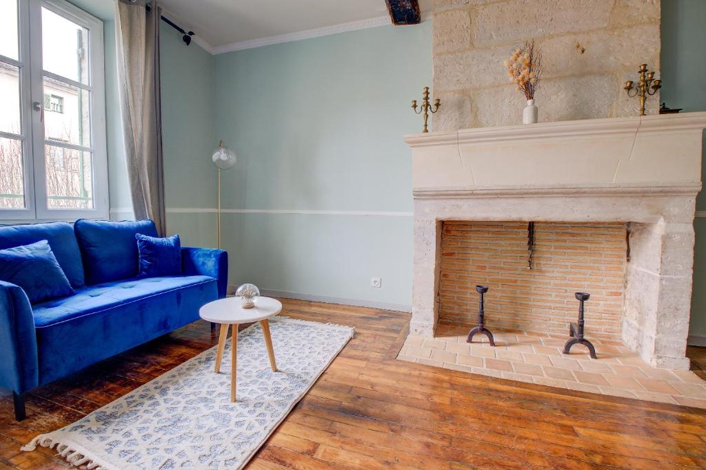 un salon avec un canapé bleu et une cheminée dans l'établissement le romantique, hyper centre, à Périgueux