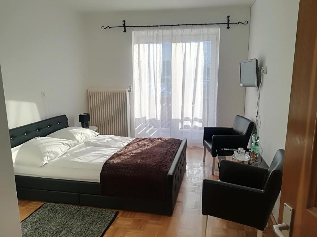 a bedroom with a bed and two chairs and a television at Ferienhaus für 10 Personen in Ulrichsberg, Oberösterreich Mühlviertel in Ulrichsberg
