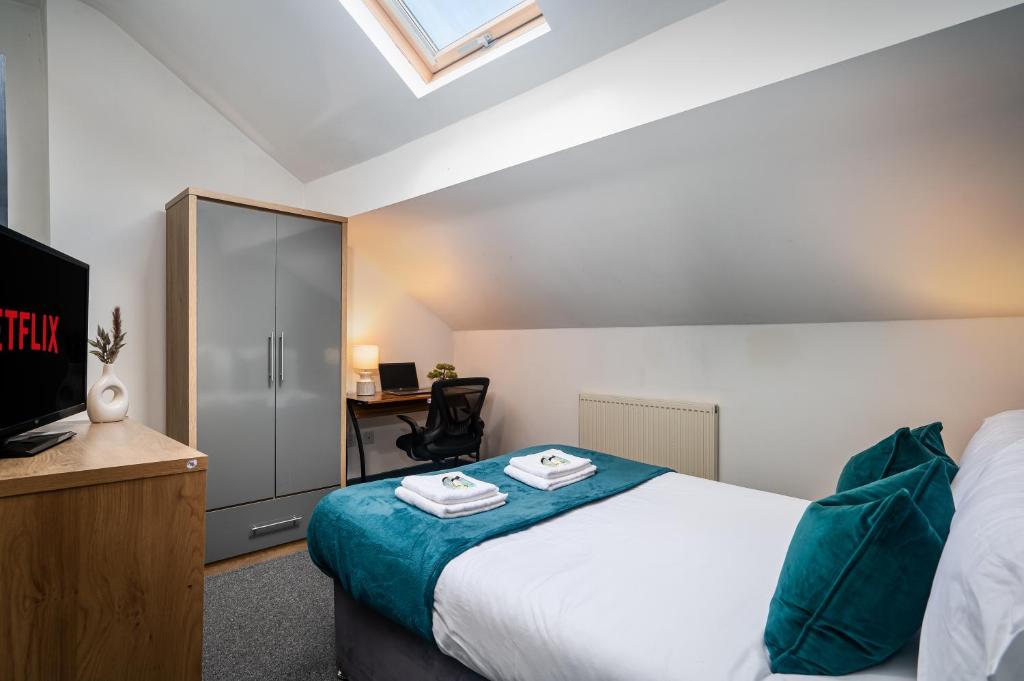 a bedroom with a bed and a desk with a tv at Private En-suite Room - Shared Living space & Kitchen - Wakefield - Central in Wakefield