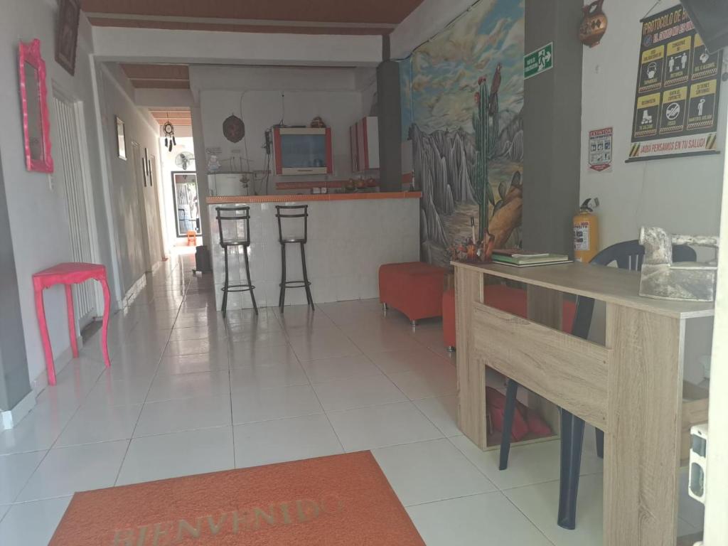 cocina y sala de estar con encimera y taburetes en HOSTAL LOS CAMINANTES, en Villavieja
