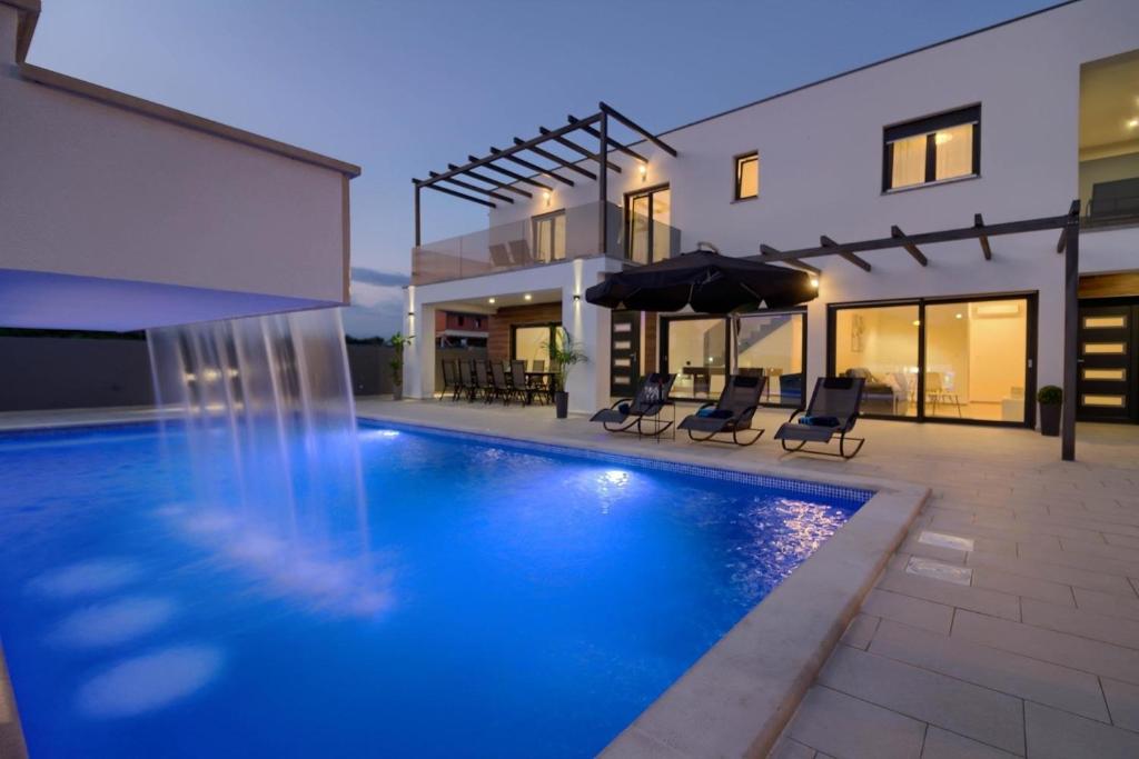 - une piscine en face d'une maison dans l'établissement Ferienhaus für 14 Personen in Loborika, Istrien Südküste von Istrien, à Loborika