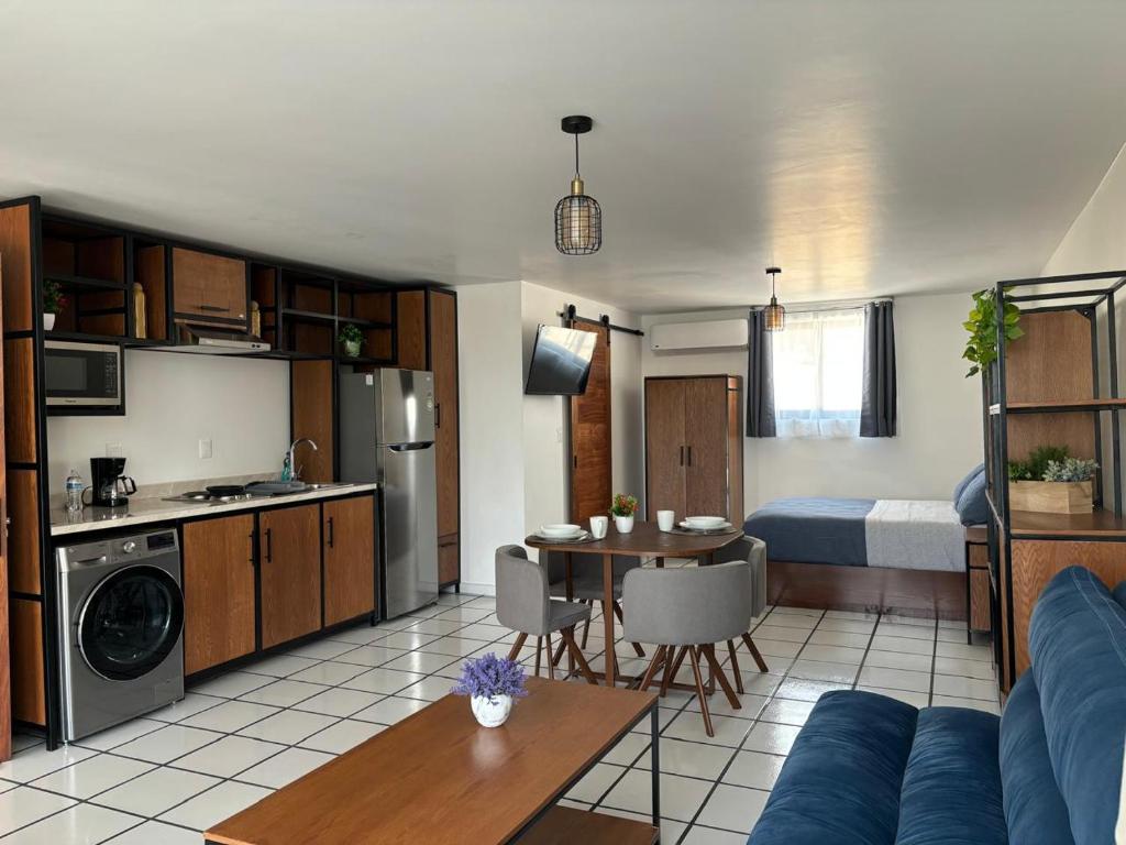 a living room with a couch and a kitchen with a table at El Encanto Lofts in Cuernavaca