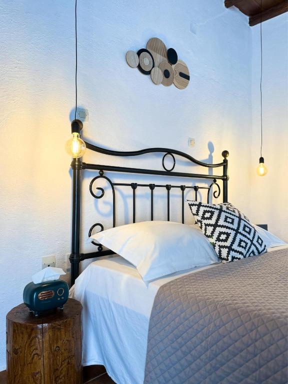 a bedroom with a bed with a black headboard at O Mylos in Ermoupoli