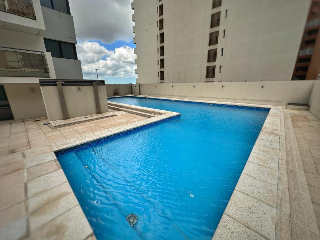 a blue swimming pool on the side of a building at Simplemente DUOMO in Córdoba