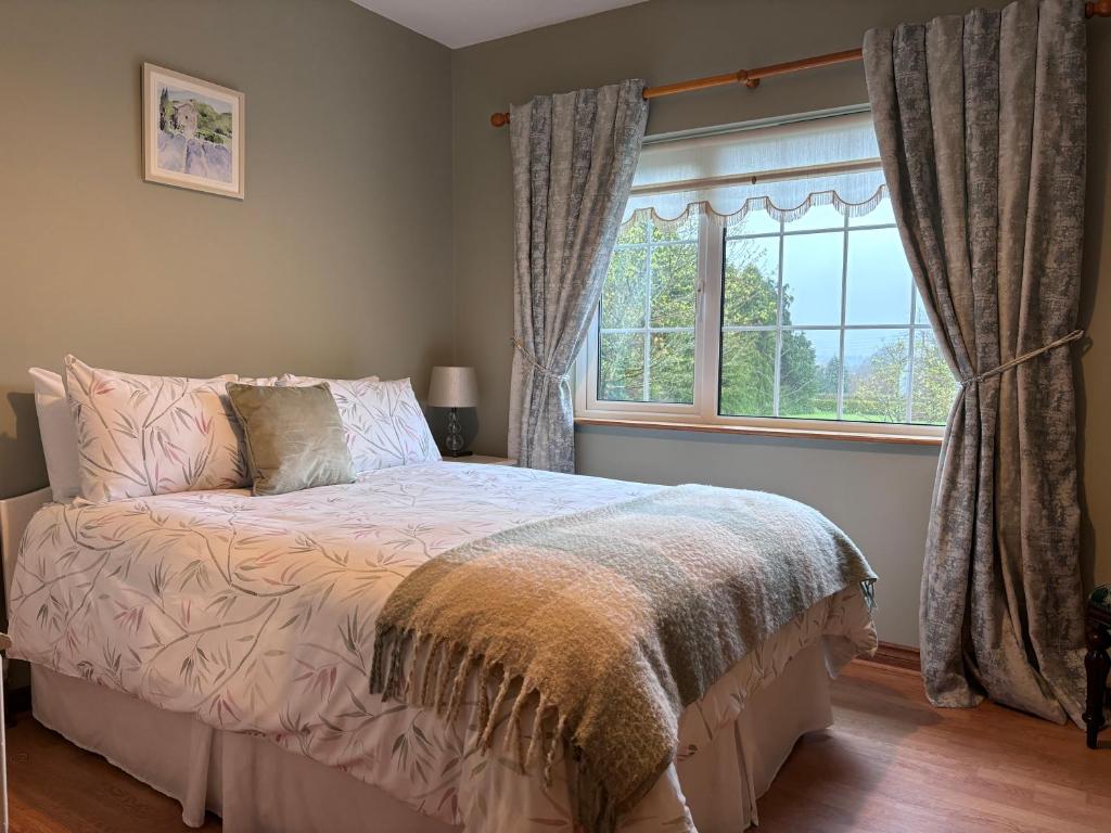 a bedroom with a bed in front of a window at The Lodge Self Catering in Castlerea