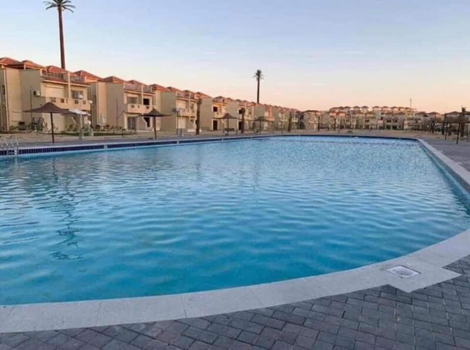 ein großer Pool mit blauem Wasser in einem Resort in der Unterkunft Stella Hieghts in El-Alamein
