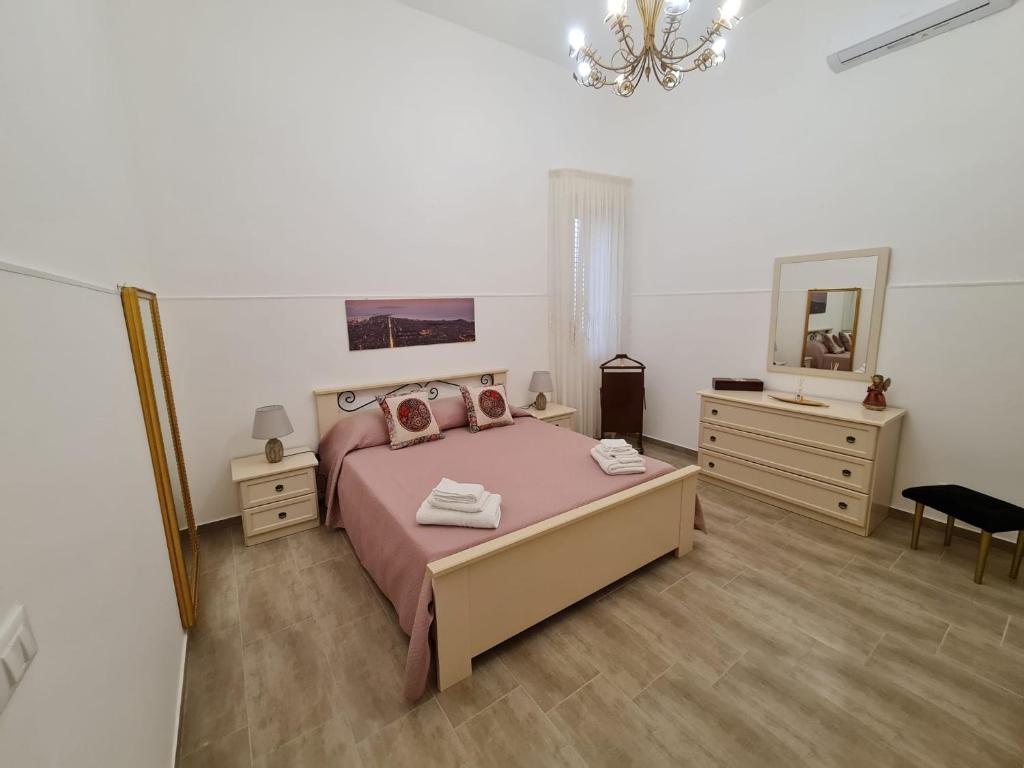 - une chambre avec un grand lit et un miroir dans l'établissement Abitazione Del Mandorlo, à Trapani