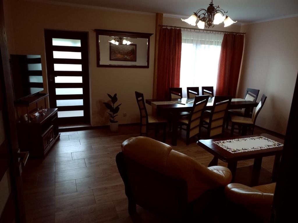 a living room with a dining room table and chairs at Miodowe wzgórze in Jastrzębia