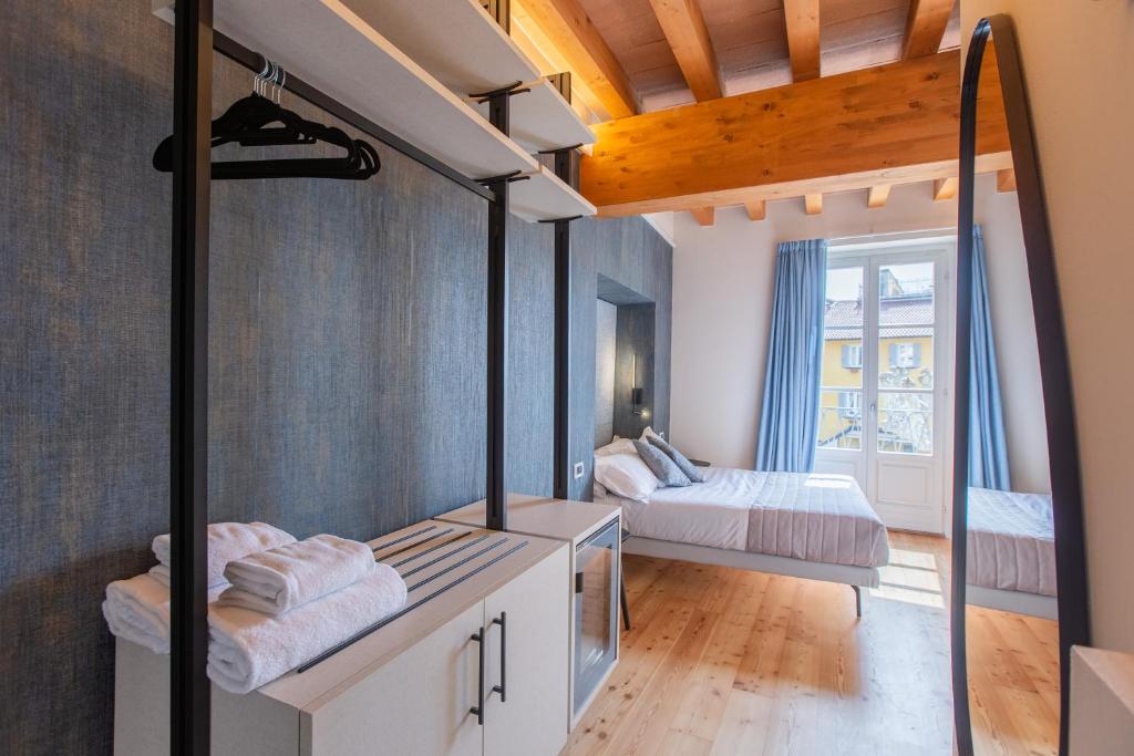 a room with two beds and a mirror at Albergo Del Sole in Varenna