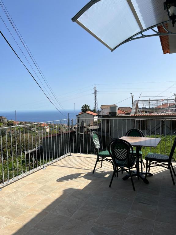 a patio with chairs and a table with a view of the ocean at Success House in Calheta