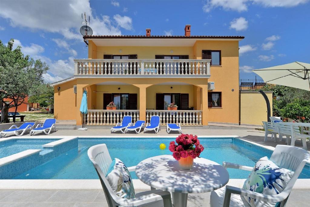 uma casa com piscina e uma mesa com um vaso de flores em Ferienhaus mit Privatpool für 16 Personen ca 190 qm in Vodnjan, Istrien Istrische Riviera em Vodnjan