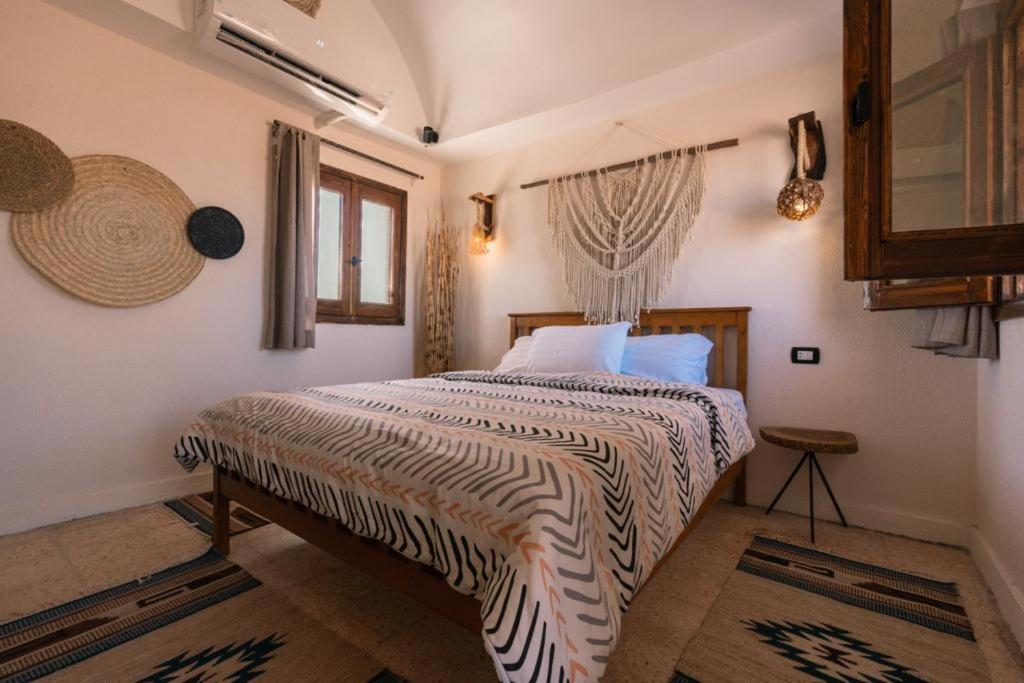 a bedroom with a bed with a striped comforter at Sukoon Camp in Nuweiba