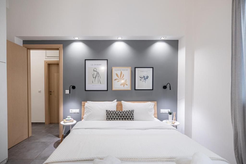 a bedroom with a large white bed and three pictures on the wall at Ports Crossroad C in Piraeus