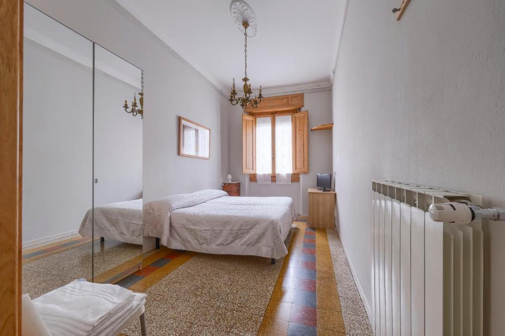 Habitación blanca con 2 camas y espejo. en Da Leonardo Apartment, en Florencia