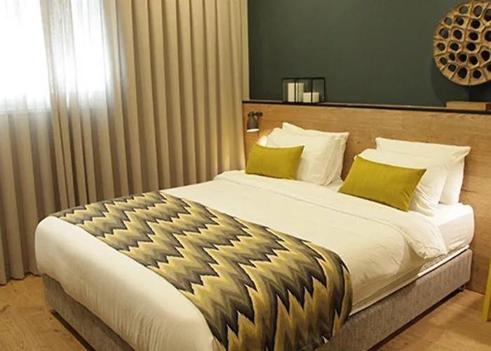 ein Schlafzimmer mit einem großen Bett mit gelben Kissen in der Unterkunft Just Like Hotel in Tel Aviv