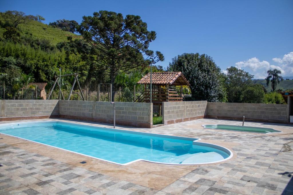 una piscina en un patio con una pared de ladrillo en Hotel Águas Lindas, en Itamonte