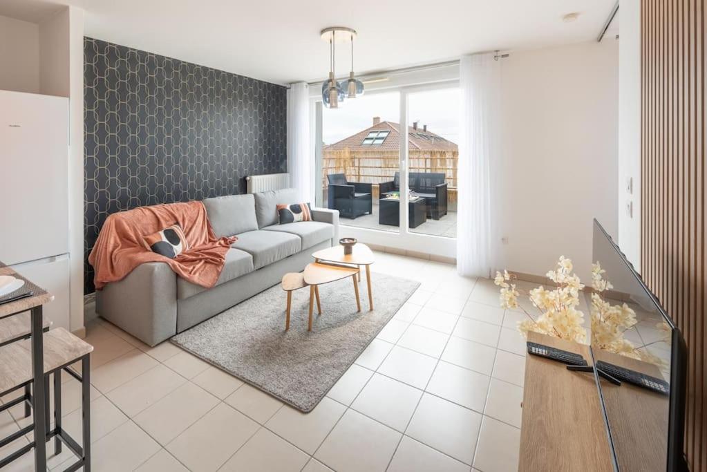 ein Wohnzimmer mit einem Sofa und einem Tisch in der Unterkunft L'excellence-Parking privé-8min Aéroport-NBSimmo in Lingolsheim