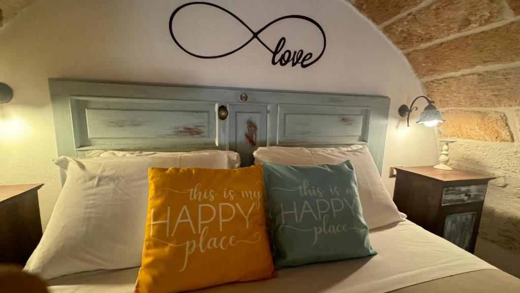 a bed with two pillows and a sign that reads this is my happy plan at B&B Casa Fiore in Polignano a Mare