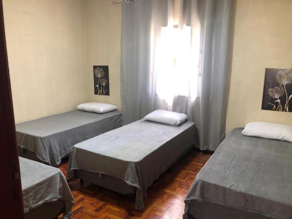 three beds in a room with a window at Casa próximo Anhanguera Jardim Lago in Campinas