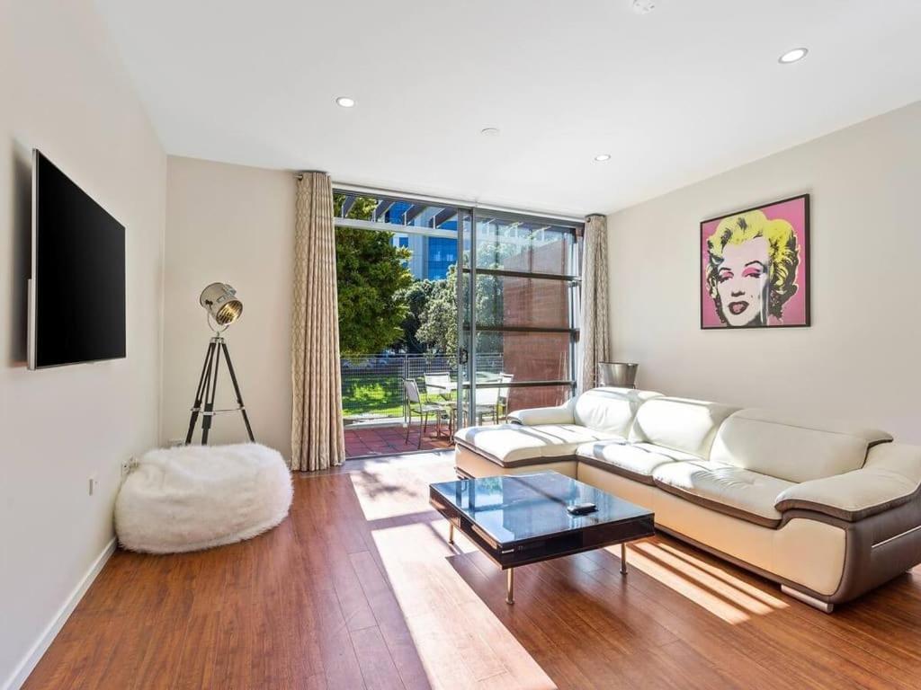 a living room with a couch and a table at Sleek Modern Pad next to Spark Arena Free Parking in Auckland