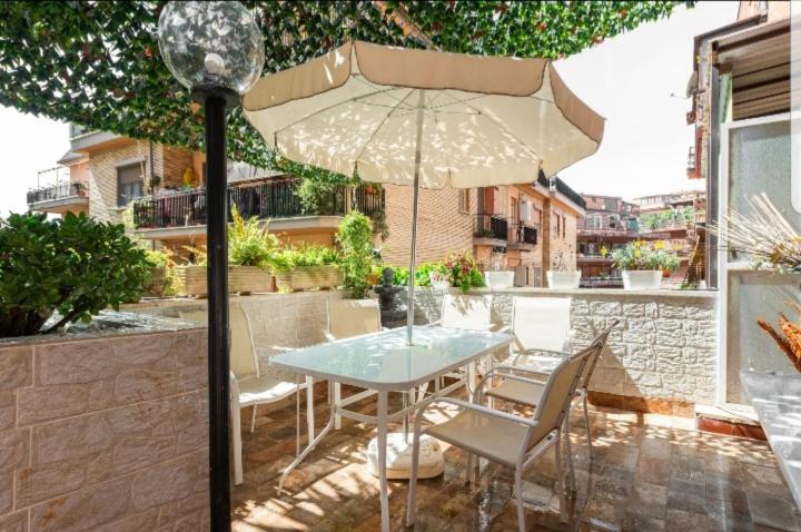 - une table et des chaises avec un parasol sur la terrasse dans l'établissement Home.sweet.Rome, à Rome