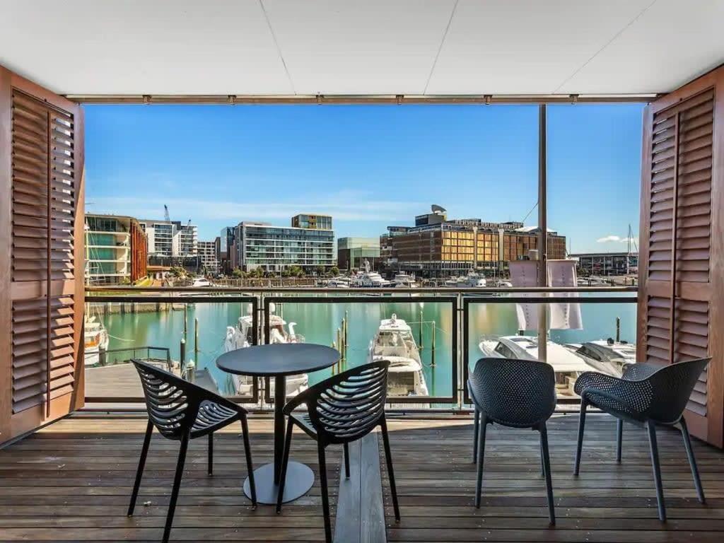 a balcony with chairs and a table and a view of a city at Lovely view apartment - free parking, pool and gym in Auckland