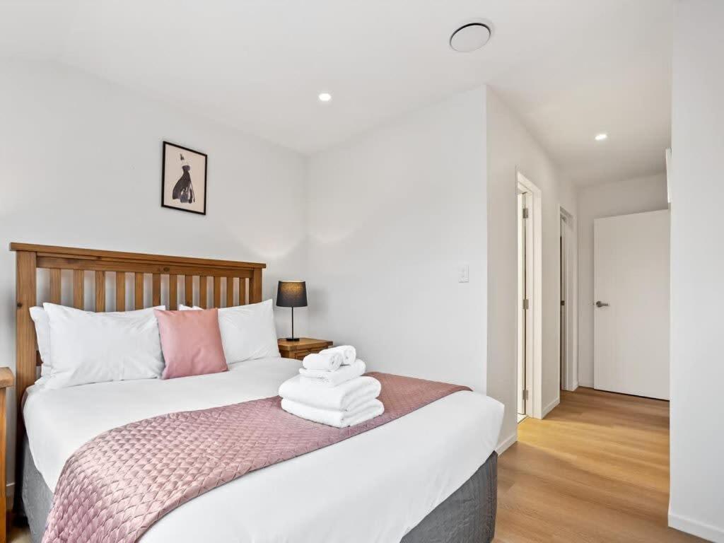 a bedroom with a bed with towels on it at Brand New Three Bedroom Townhouse with Garage in Auckland