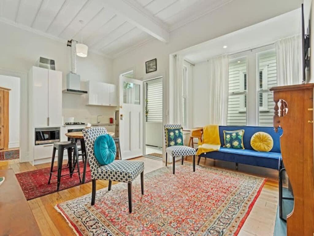 un soggiorno con divano blu e sedie di Cheerful 1 Bedroom Home with Free Parking ad Auckland