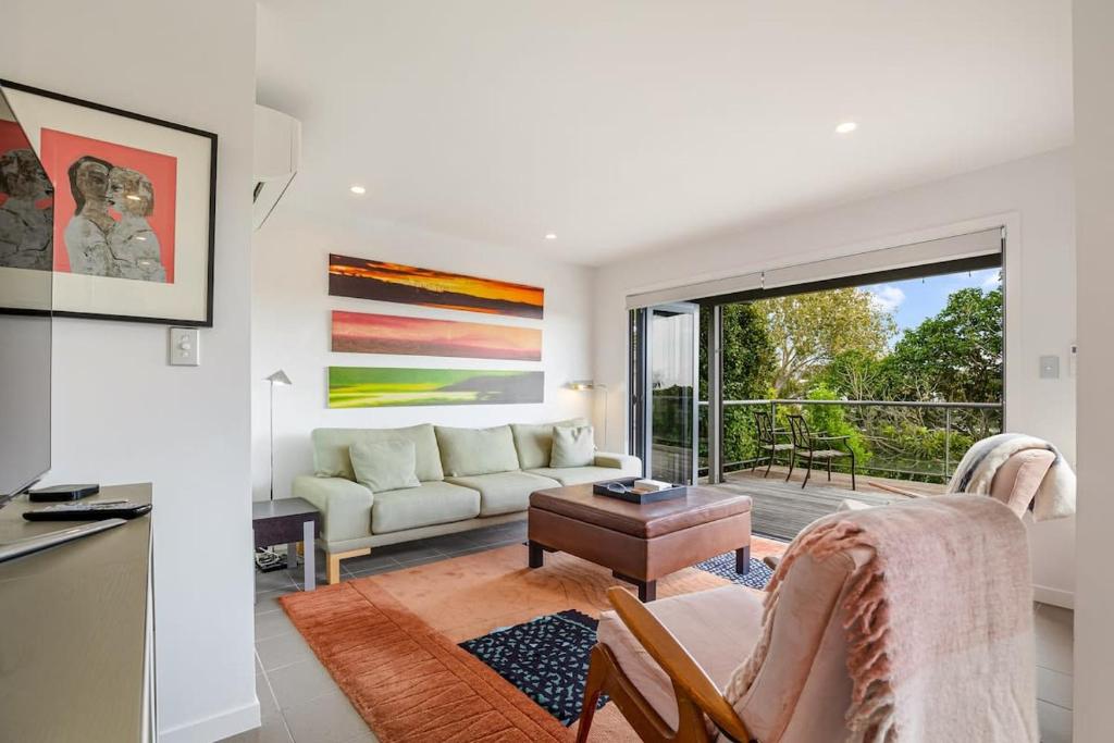 a living room with a couch and a table at Stylish and serene living in Kohimarama in Auckland